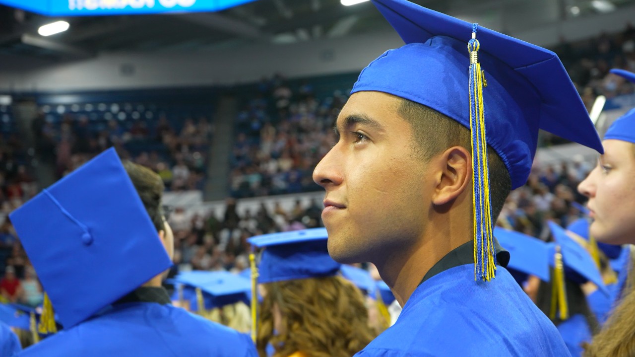An RHS student looks to family from the graduation floor.